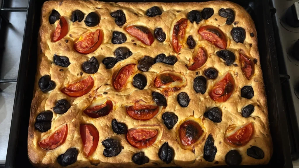 Tepside pişirilmiş domates ve zeytinli ev yapımı İtalyan focaccia ekmeği